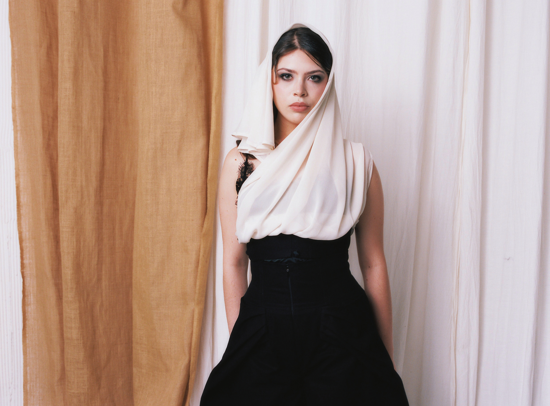 Monáe Simpson — Insurgent Veiled portrait against a warm draped backdrop